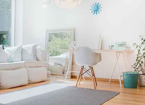 Image of nicely decorated white room with desk and rug
