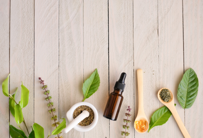 Table with leaves, herbs, and other natural ingredients to make greener bathroom cleaners