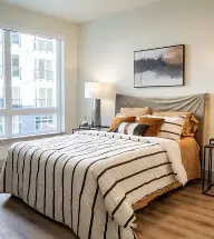 Bright modern apartment bedroom with striped bedding
