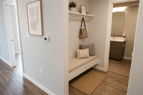 A hallway with a bench and a painting on the wall.