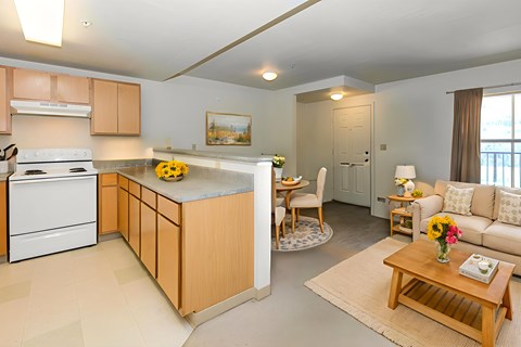 A kitchen with a white stove and wooden cabinets.