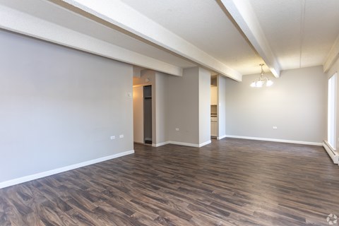 A room with wooden flooring and white walls.