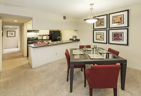 a dining room and kitchen with a table and chairs