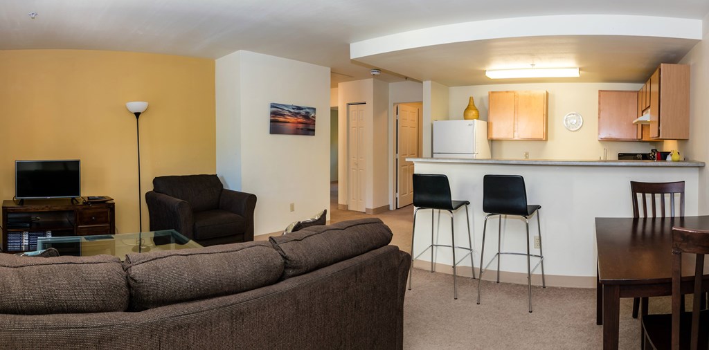 A living room with a couch, chairs, and a television.