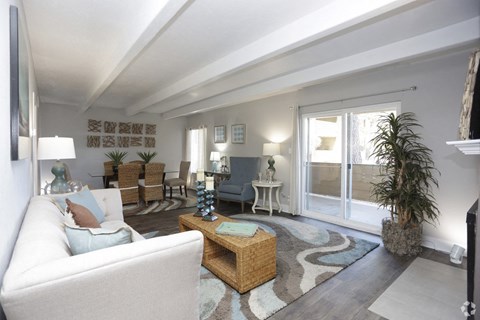 A living room with a white couch and a wooden coffee table.