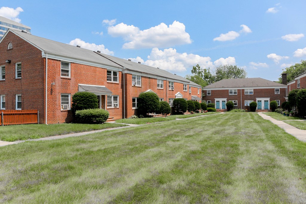 a large yard in front of a brick apartment building
