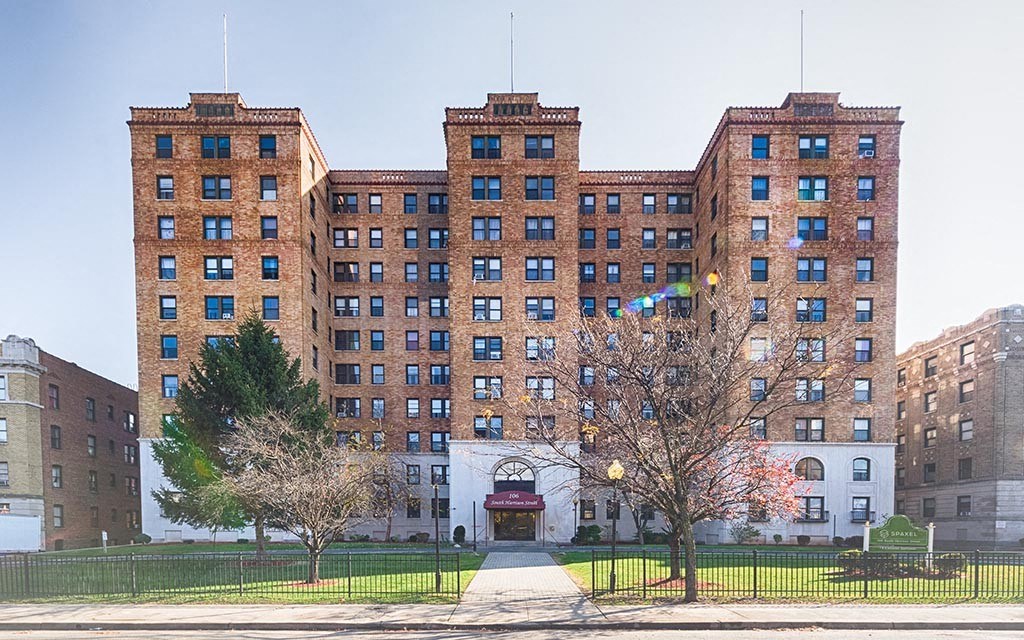 a large brick building with a sidewalk in front of it