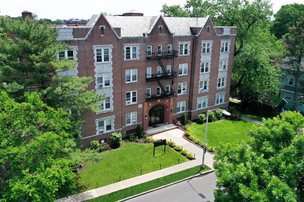 an aerial view of a brick building with grass and trees