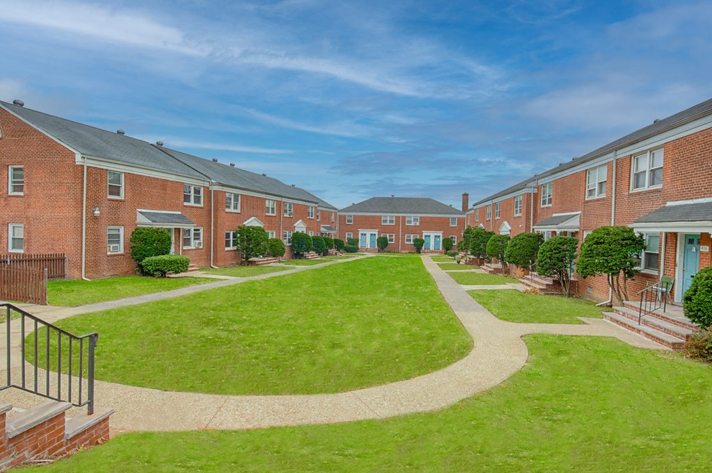 an image of an apartment complex with a green courtyard