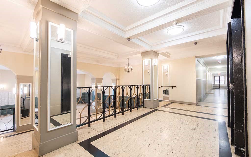the lobby of a building with a staircase and mirrors