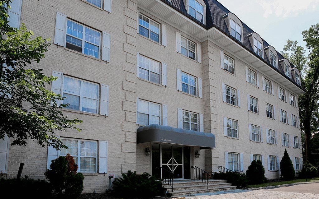 a large brick apartment building with a black awning