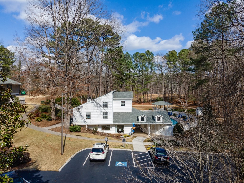 an aerial view of a white house with cars parked in front of it