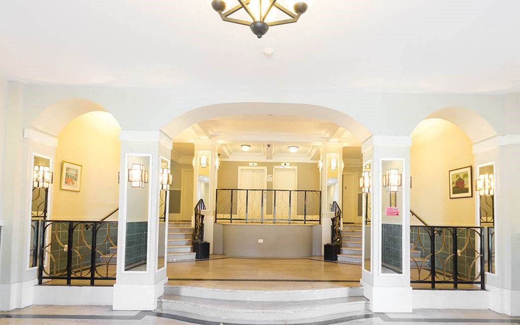 the lobby of a building with stairs and a chandelier