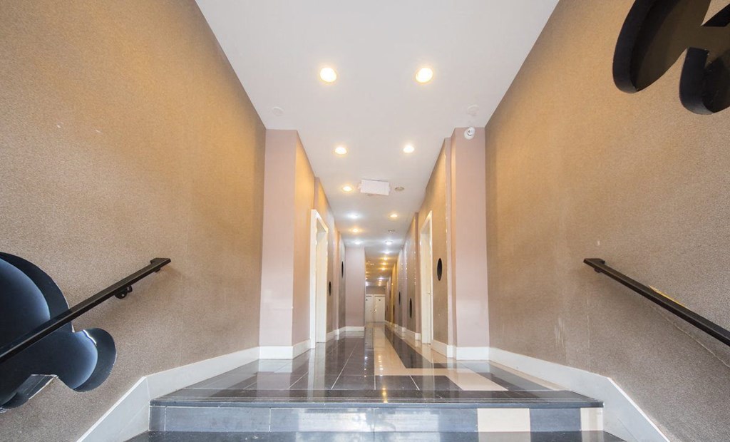a long hallway with black railings and a glass floor