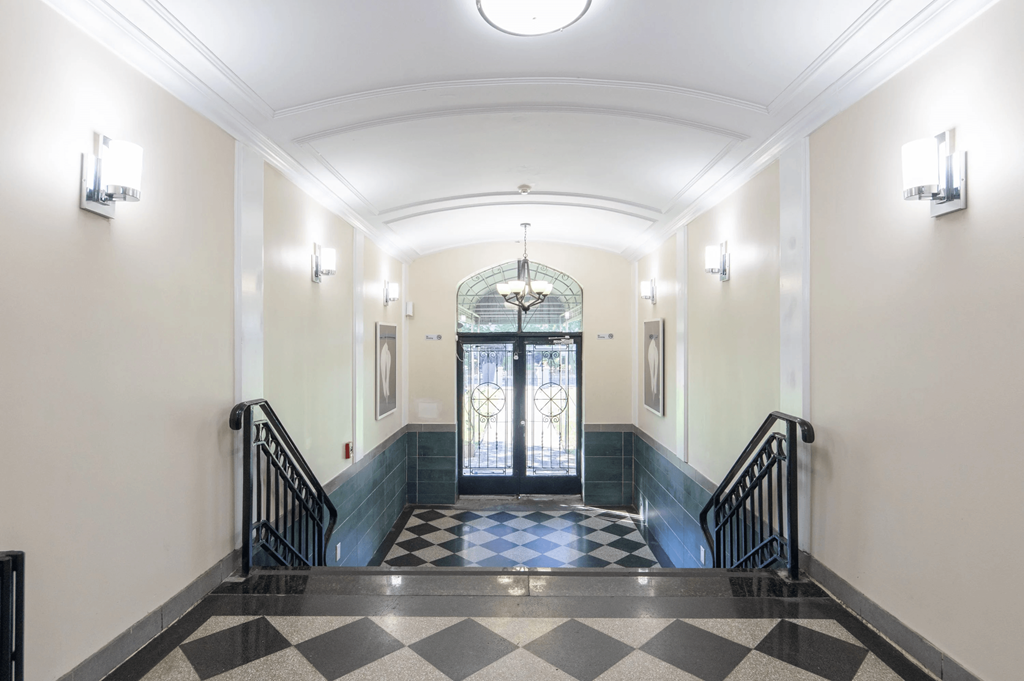 the lobby of a building with stairs and a glass door