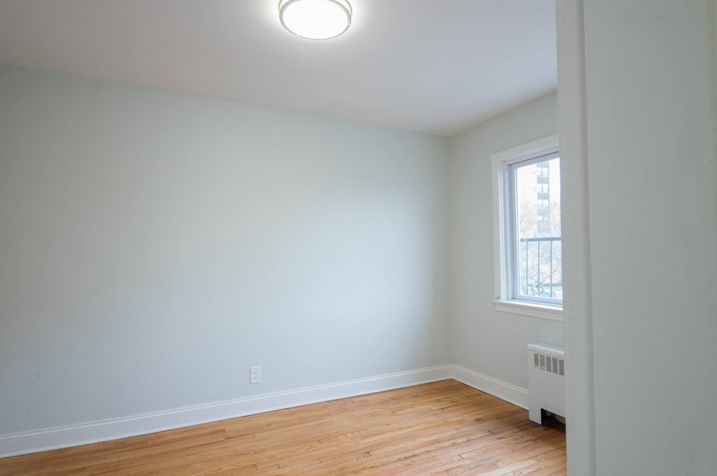 an empty room with white walls and a window
