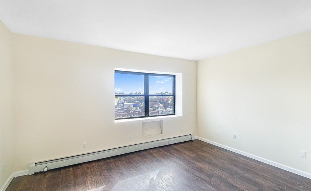 an empty room with wood floors and a window