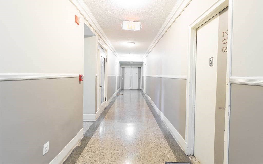 a hallway with white walls and white doors and a tile floor