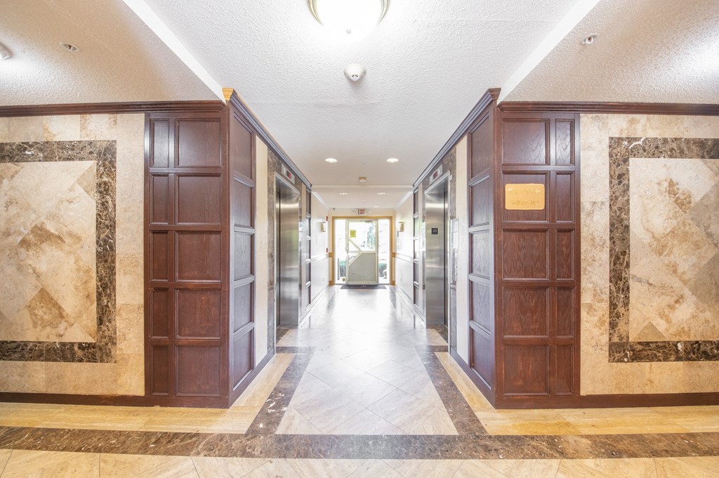 a lobby with wooden doors and a tile floor