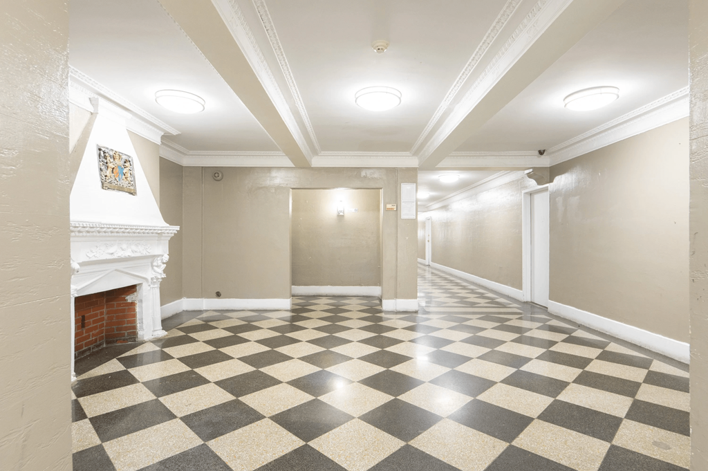 an empty room with a fireplace and a checkered floor