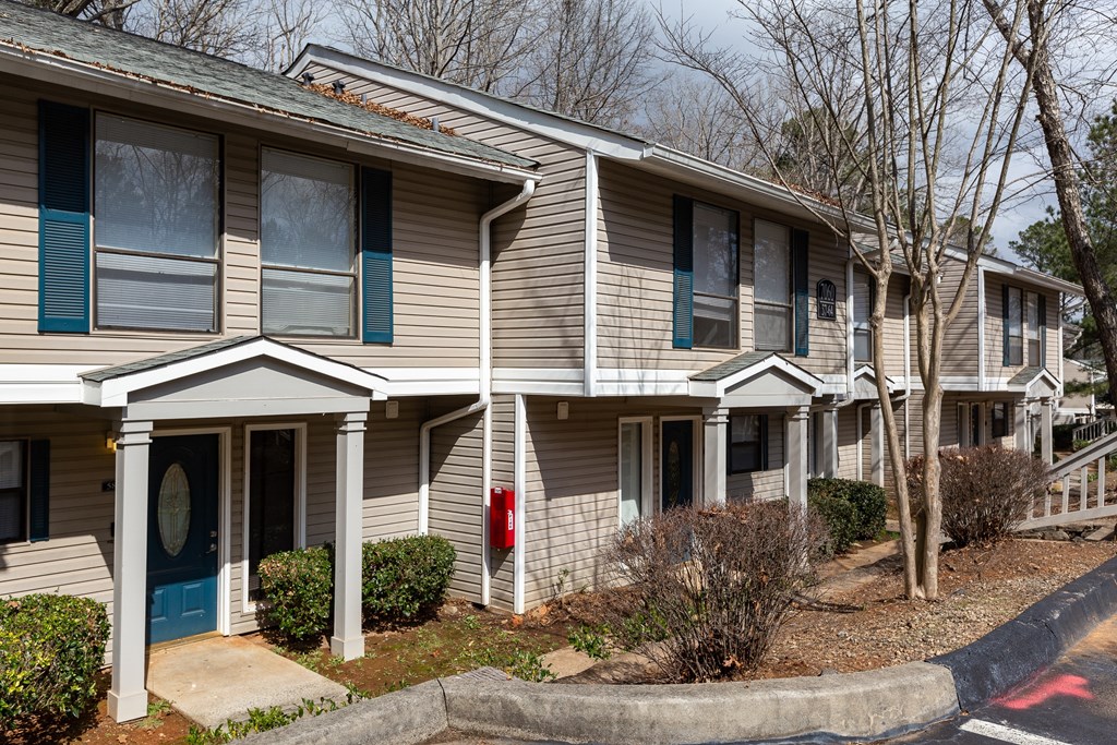a tan house with blue trim and a red mailbox