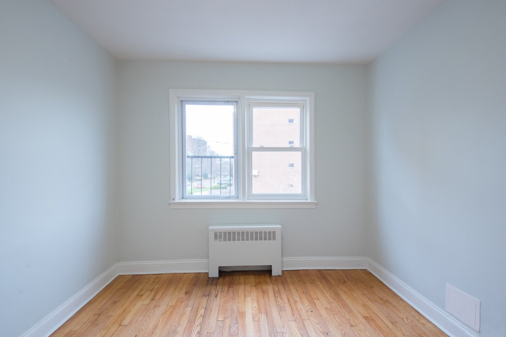 an empty room with a radiator and a window