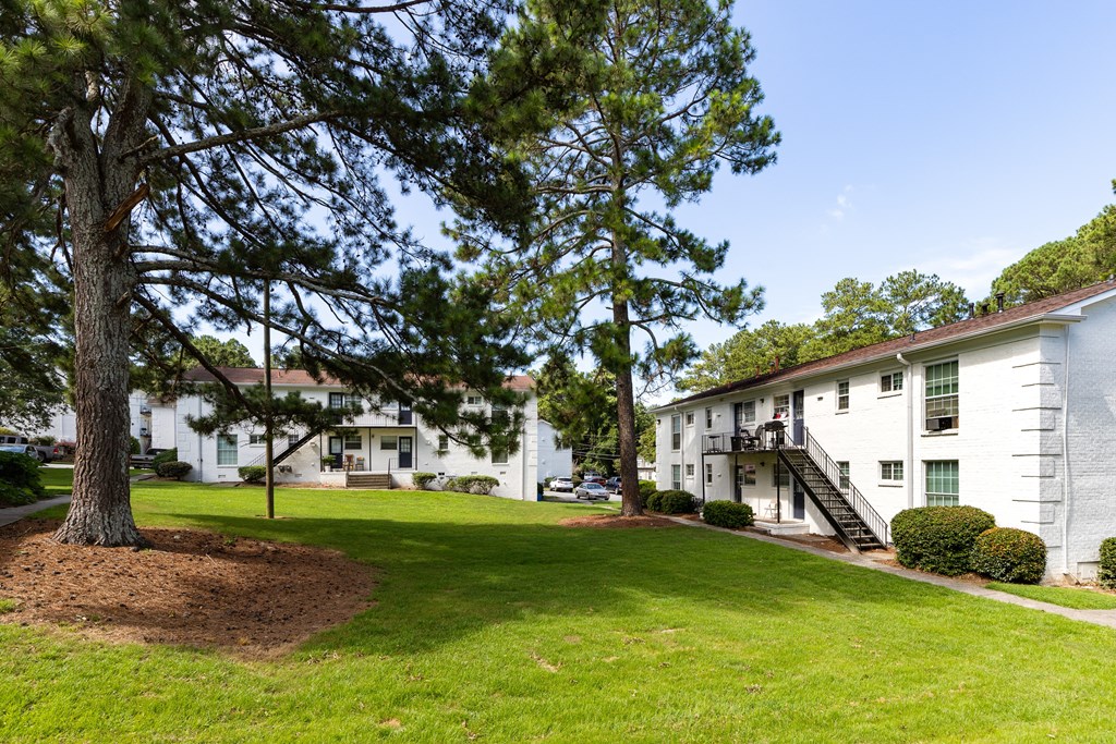 the view of a building with a lawn and trees