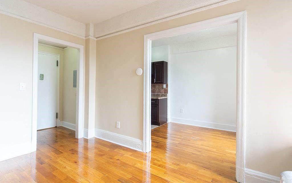 an empty living room with a hard wood floor
