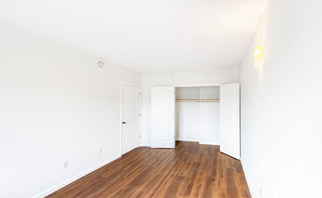 an empty room with white walls and wood floors