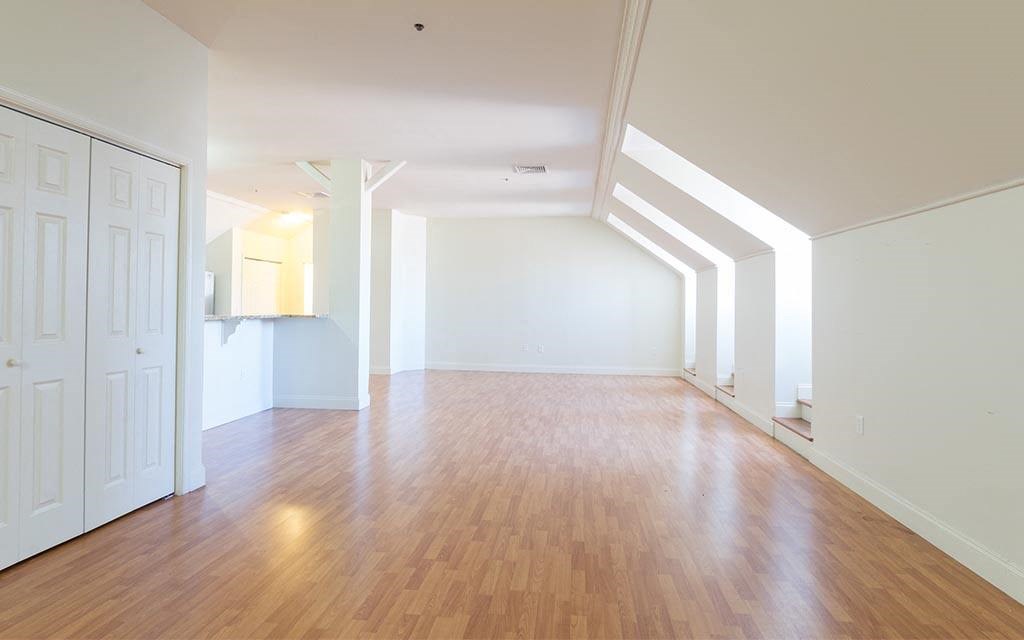 an empty living room with white walls and wood floors