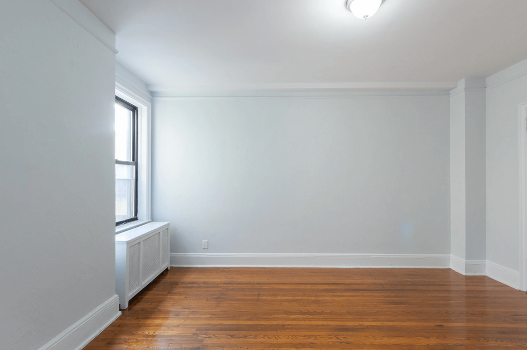 an empty room with white walls and a window