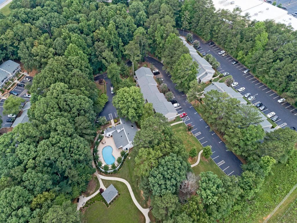 an overhead view of a park with a swimming pool and a parking lot