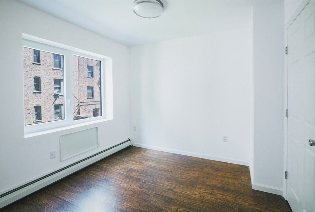 a living room with a large window and wooden floors