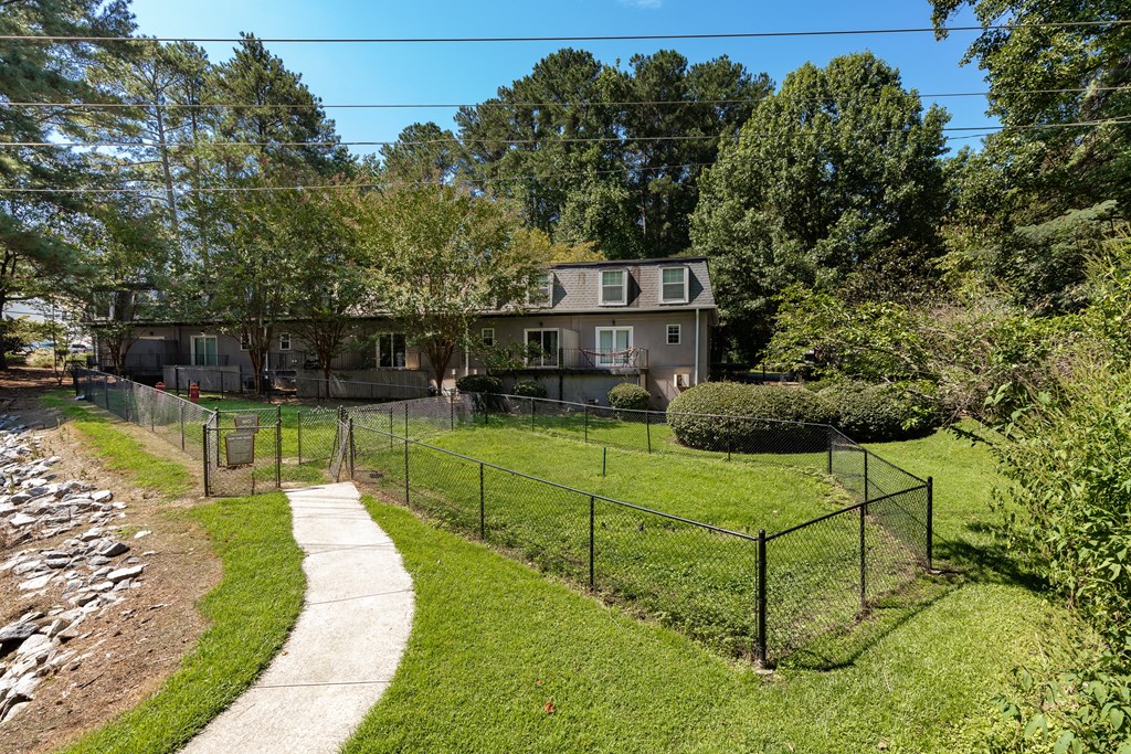 a house with a fenced in yard and a sidewalk