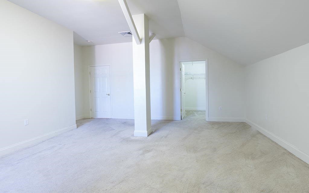 an empty living room with white walls and concrete floors