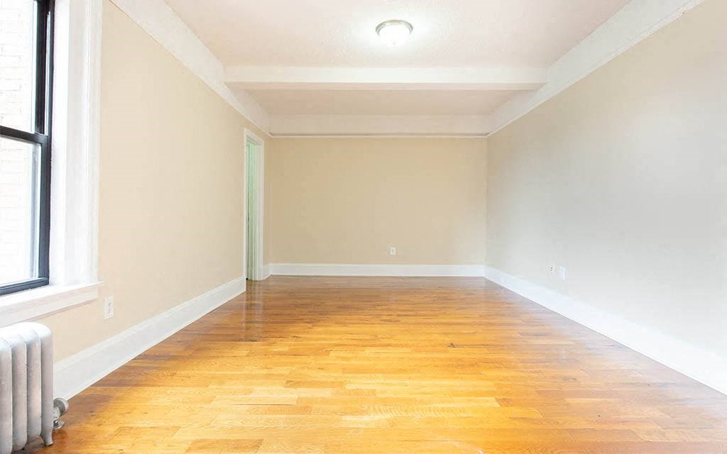 a empty room with a wood floor and a window