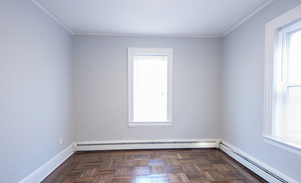 an empty room with a window and a wooden floor