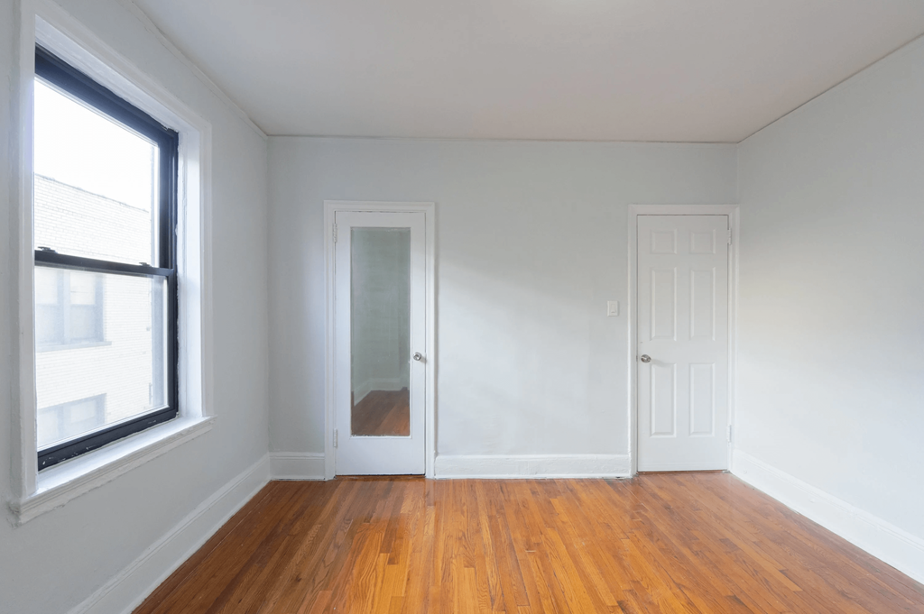 an empty room with white walls and a window and a door