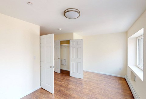 a empty room with white walls and a wood floor