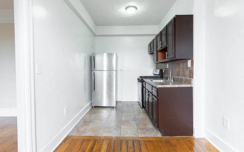 an empty kitchen with a stainless steel refrigerator