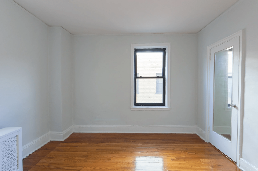 an empty room with a window and a door