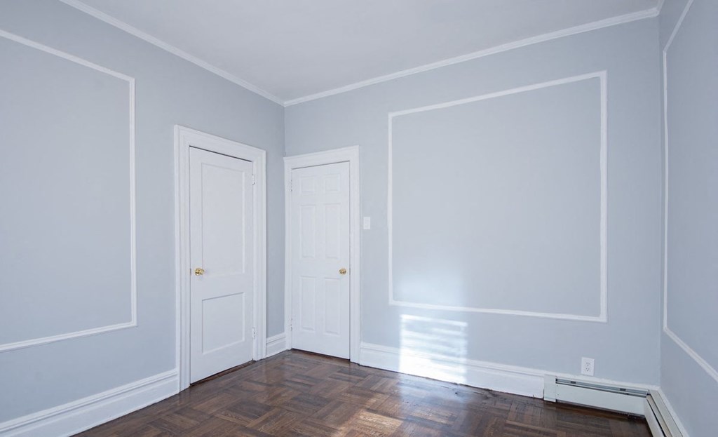 an empty room with two doors and a wood floor