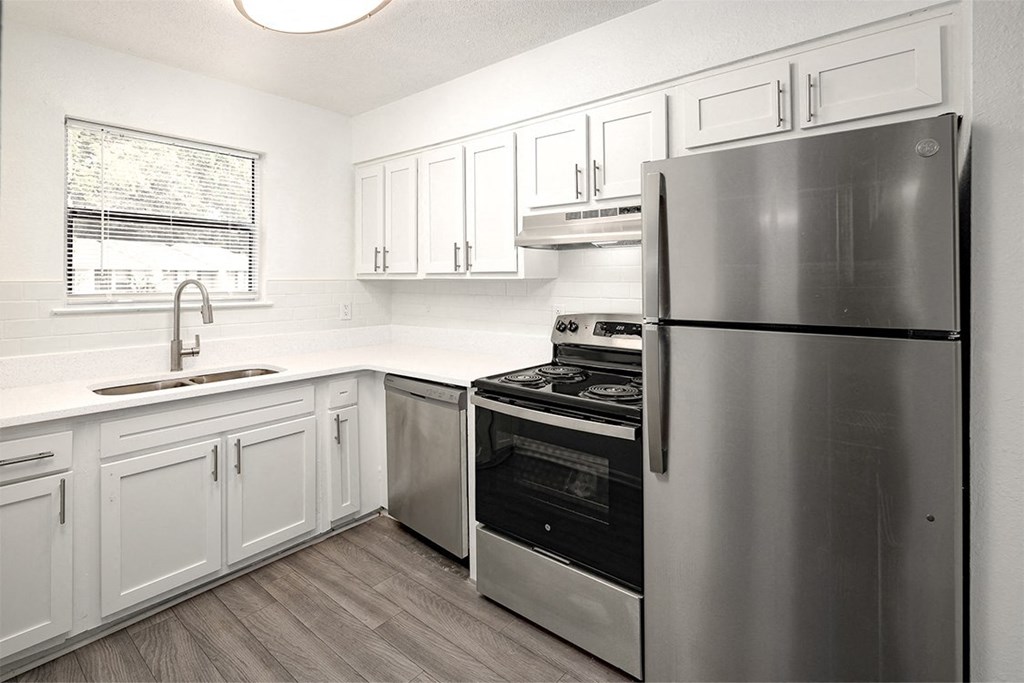 a kitchen with stainless steel appliances and white cabinets
