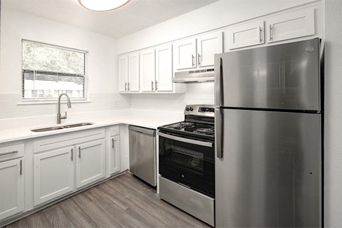 a kitchen with stainless steel appliances and white cabinets