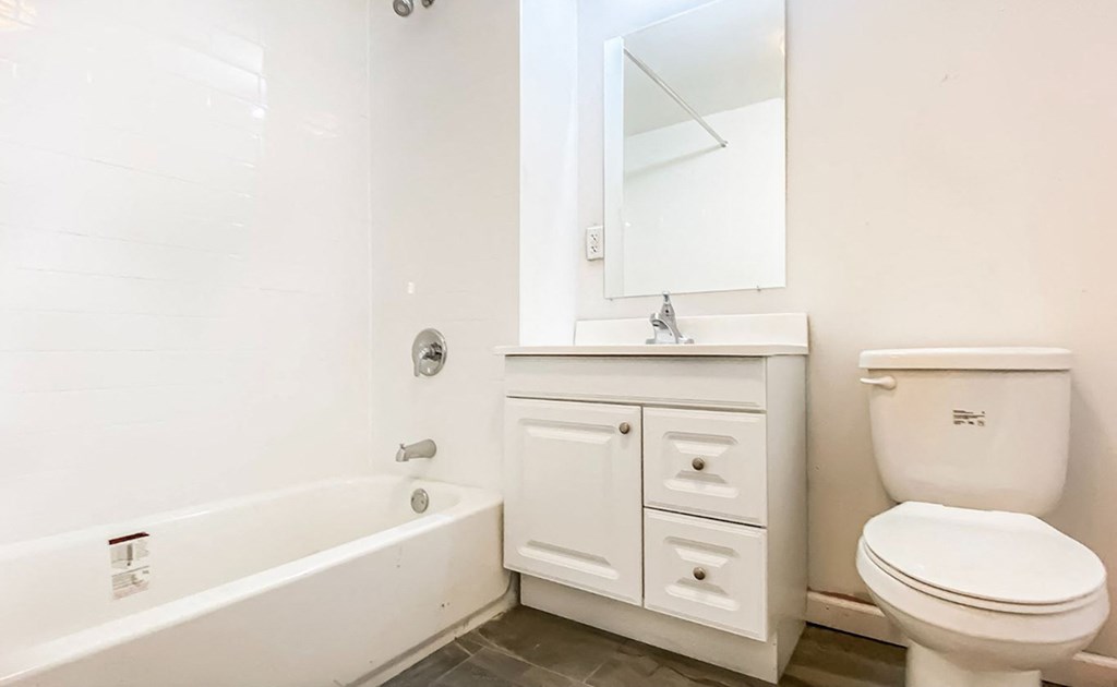 a bathroom with a toilet and a tub and a sink