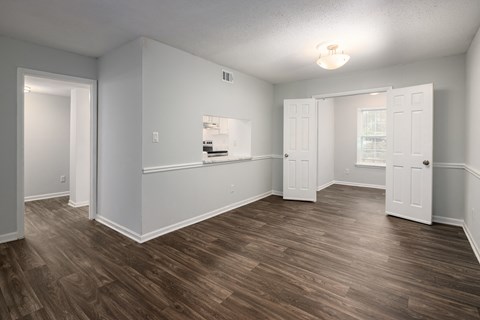 an empty living room with wood flooring and white walls