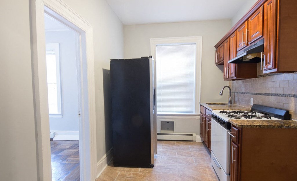 a kitchen with a refrigerator and a stove and a window