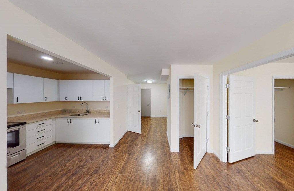 an empty living room with white walls and wooden floors