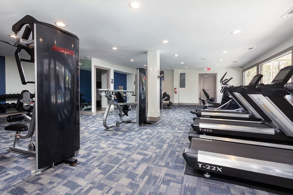 a gym with treadmills and other exercise equipment in a building with white ceilings