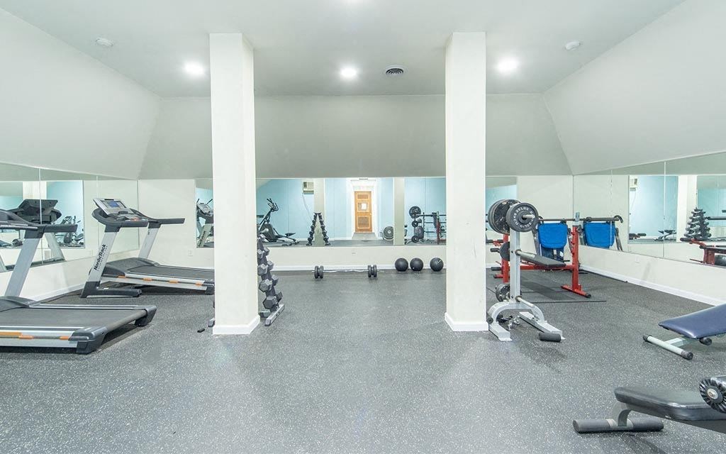 a gym with weights and other exercise equipment in a large room